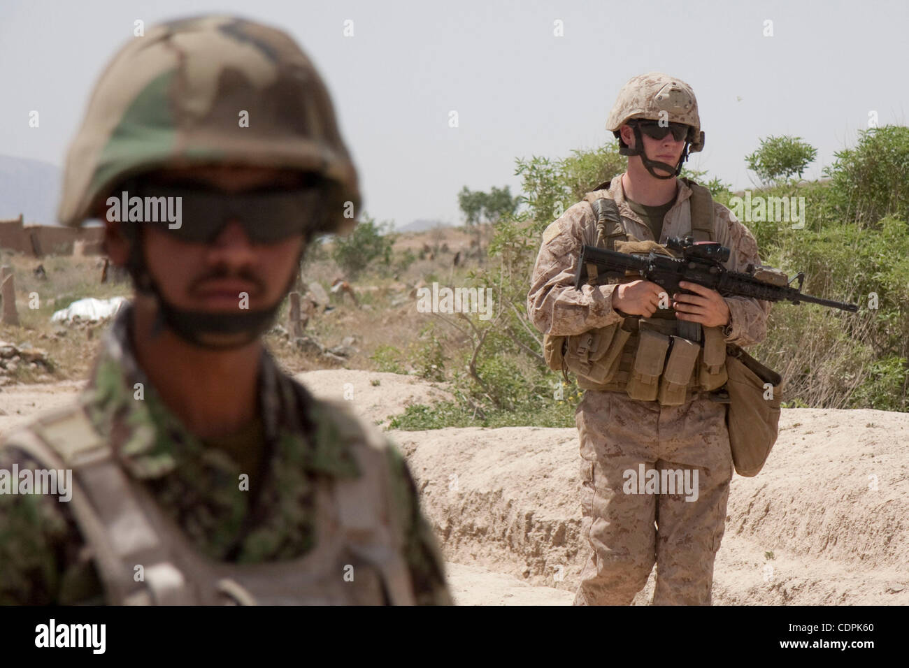 Apr 27, 2011 - Town of Naw Zad, Naw Zad district, Helmand, Afghanistan - An ANA soldier from 4th Company, 3rd Kandak, 2nd Brigade of 215th Afghan National Army Corps (left) walks back to the base after a joint patrol with Marines of Lima Company, 3rd Battalion of 2nd Marine Regiment in the Bazar of  Stock Photo