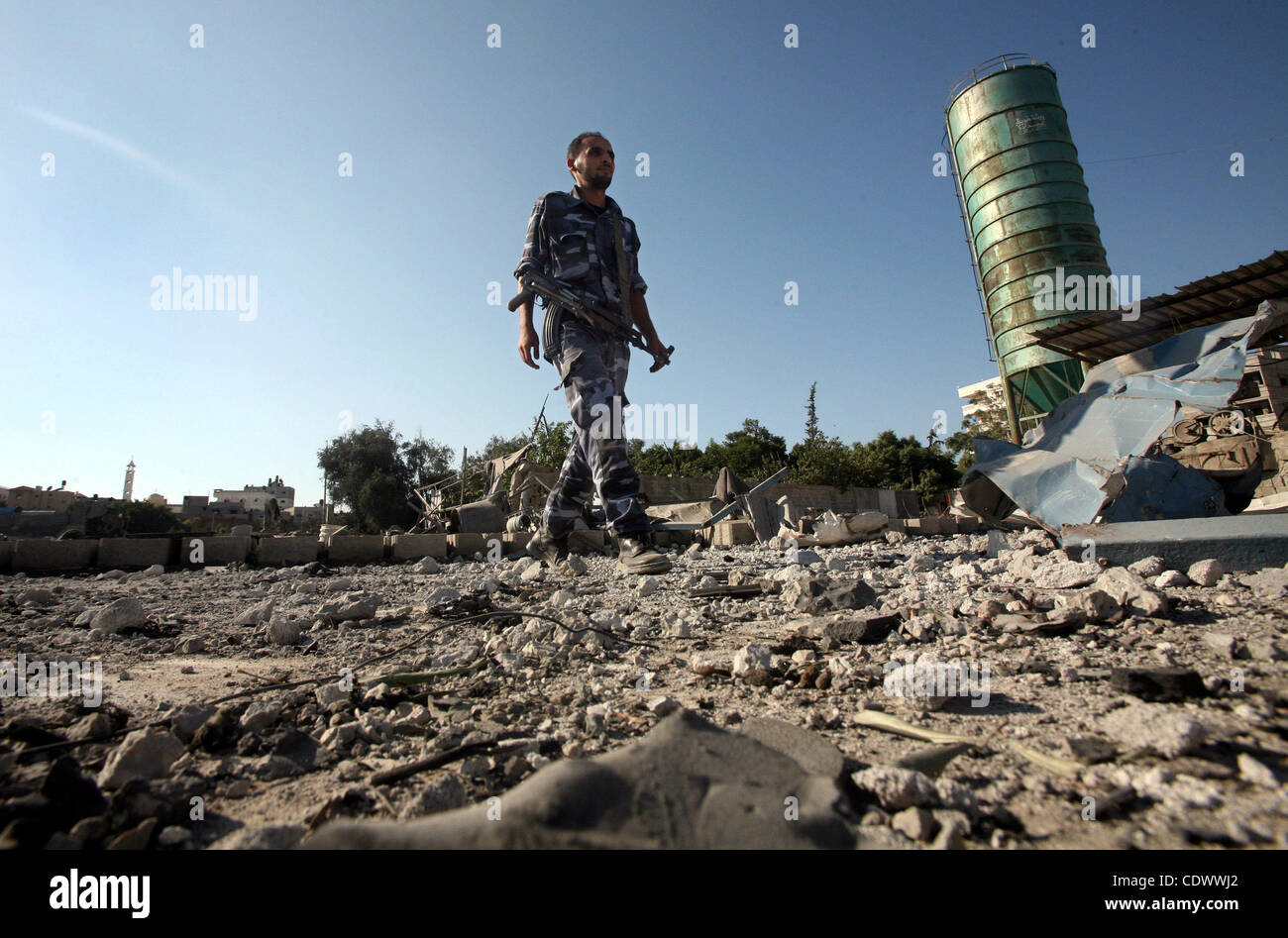 A Hamas security man inspects the damage at a Hamas training camp following an Israeli air-strike in Gaza City, Sunday, Aug. 21, 2011. Militants in the Hamas-ruled Gaza Strip bombarded southern Israel with rockets and mortars Sunday and Israel hit back with an airstrike, as diplomats scrambled to ke Stock Photo