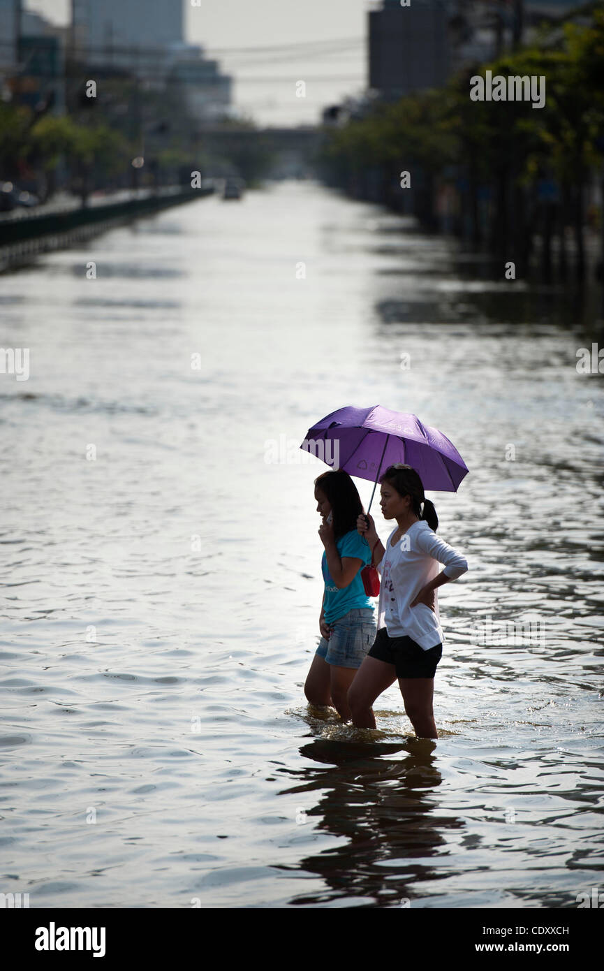 Nov. 7, 2011 - Bangkok, Bangkok, Thailand - Two young girls travers the main road through knee-high flood water in Lad Phrao district Bangkok.Levels of floodwaters in Lad Phrao district have increased over the weekend pushing the government to announce evacuation of several more districts in Lad Phr Stock Photo