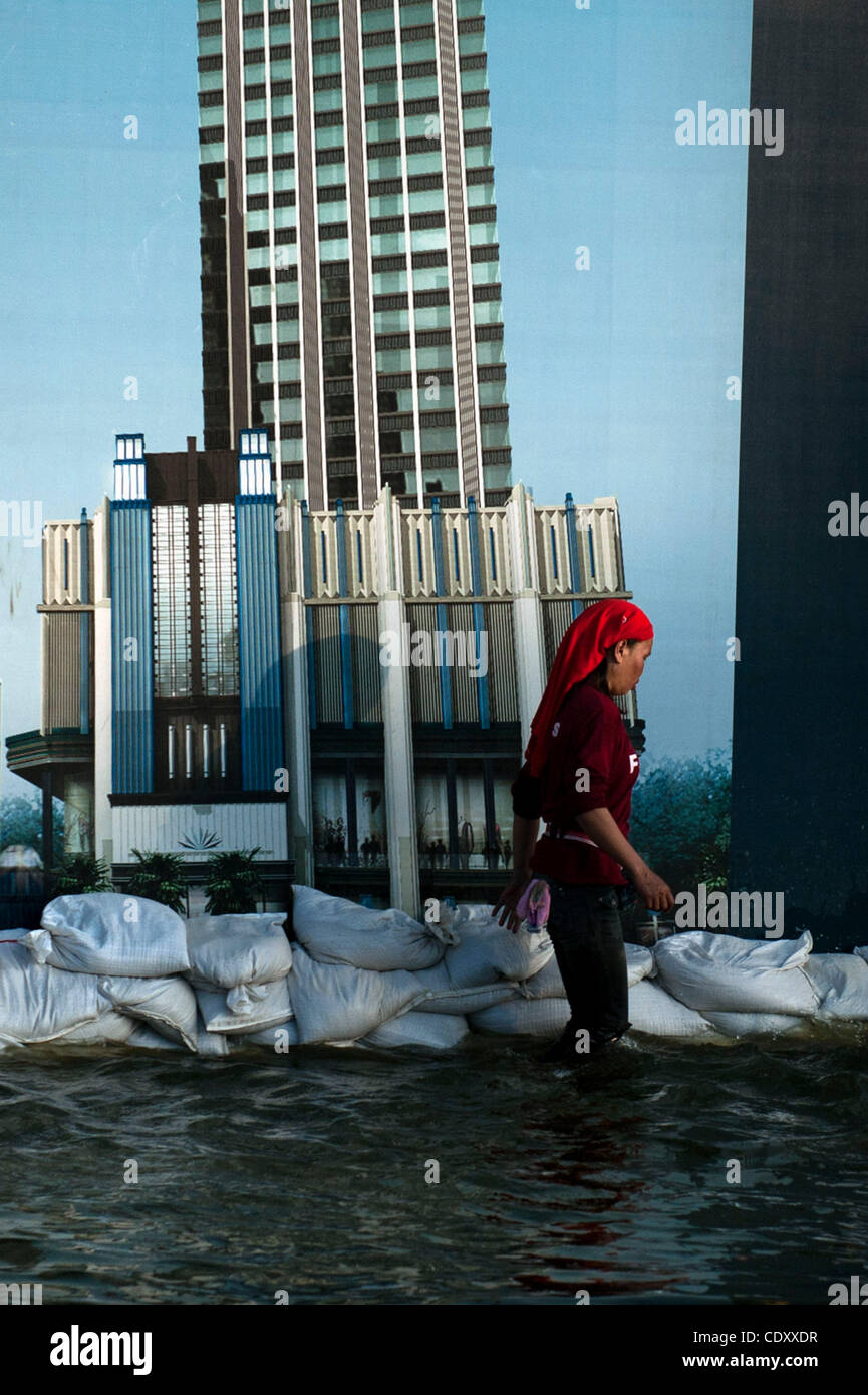 Nov. 7, 2011 - Bangkok, Bangkok, Thailand - A woman passes by the construction site while makes her way though  flooded streets in Lad Phrao..Levels of floodwaters in Lad Phrao district have increased over the weekend pushing the government to announce evacuation of several more districts in Lad Phr Stock Photo