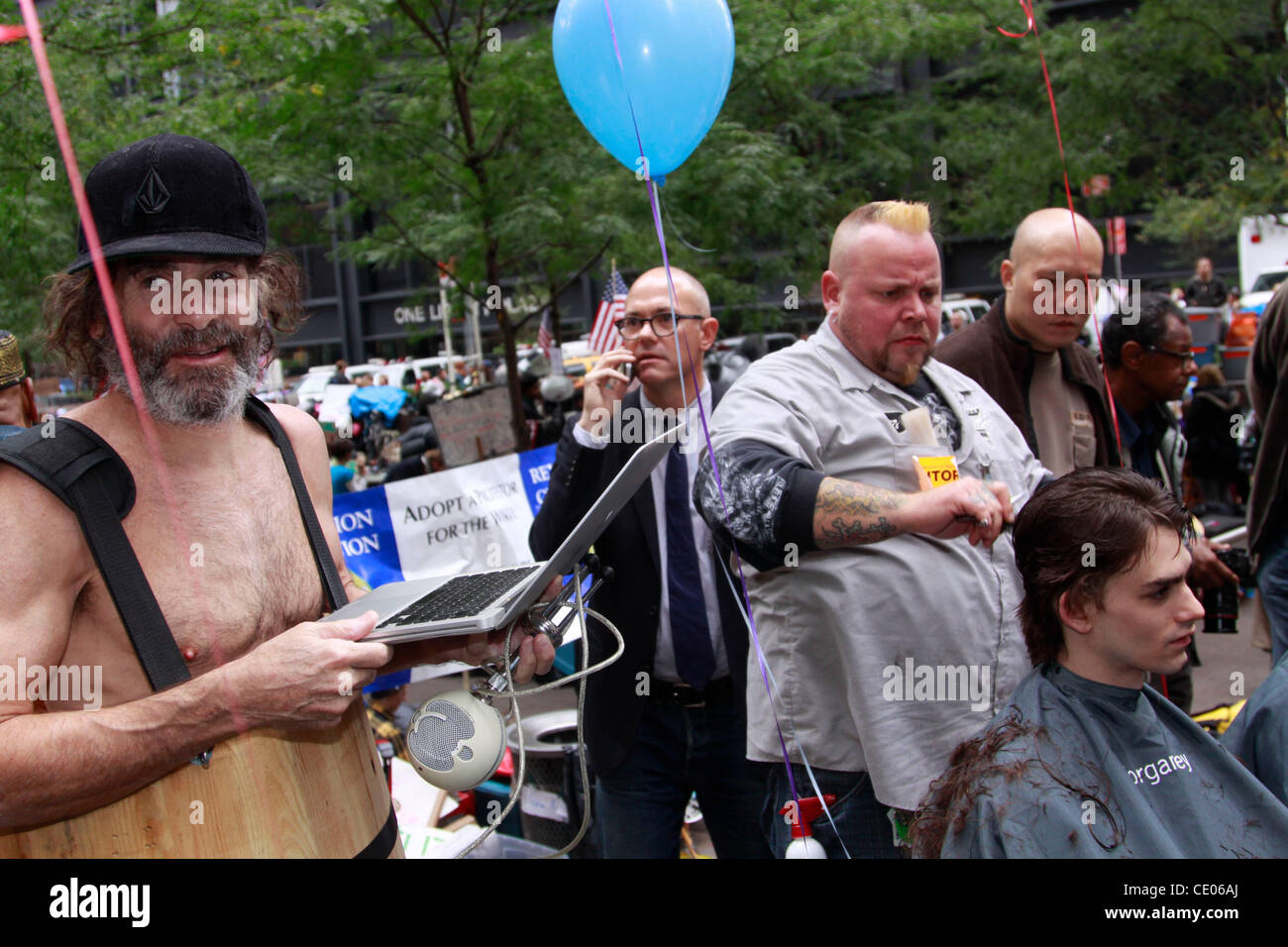 Symbolic haircuts at the Occupy Wall Street protest in Zuccotti Park. 'In banking, when a lender has to accept that a loan will not be paid back in full, the lender must then write the loan value down for a loss. This is called taking a haircut.' Stock Photo