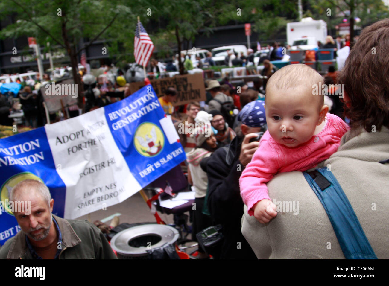 A baby goes for a ride through the Occupy Wall Street protest in Zuccotti Park. Some call it a shanty town and a circus. Others call it a political and social revolution. Stock Photo