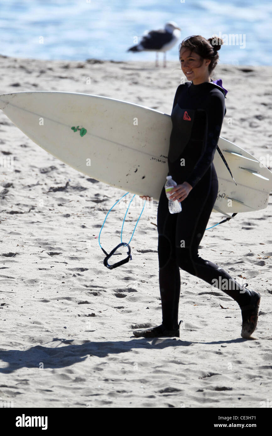 Cast members of the television show '90210' film a beach scene with wetsuits and surfboards in