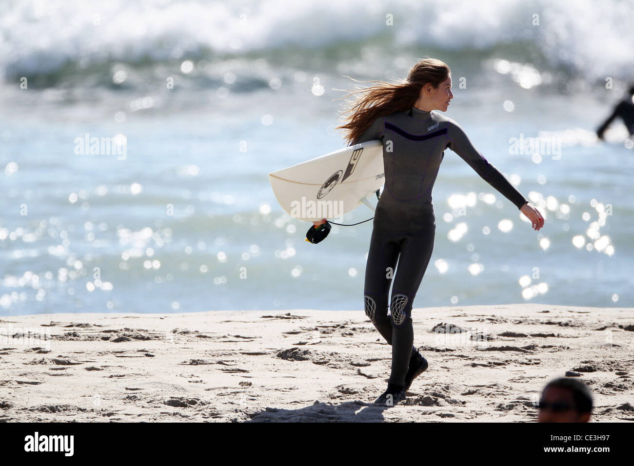 Cast members of the television show '90210' film a beach scene with wetsuits and surfboards in