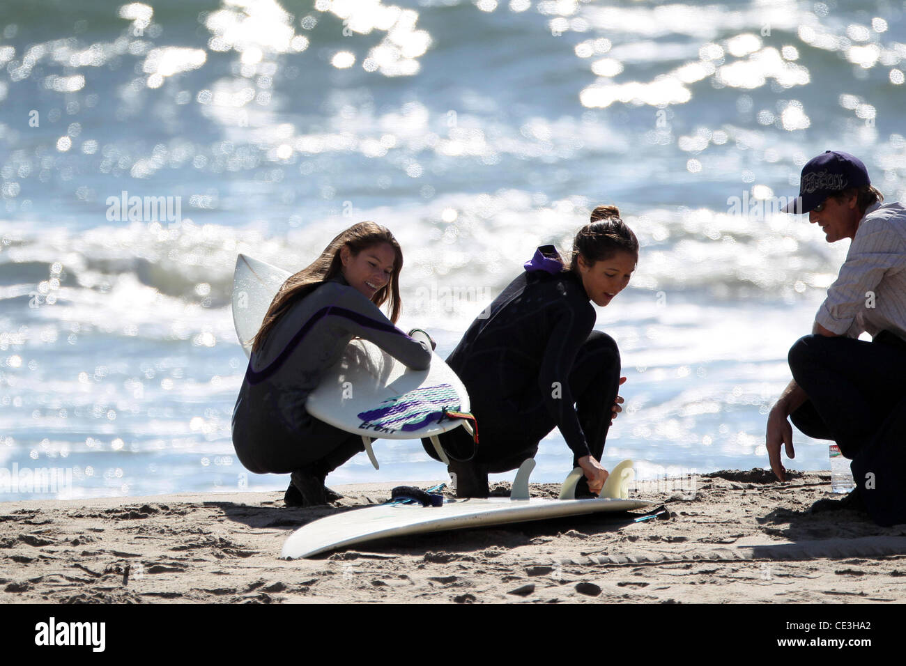 Cast members of the television show '90210' film a beach scene with wetsuits and surfboards in