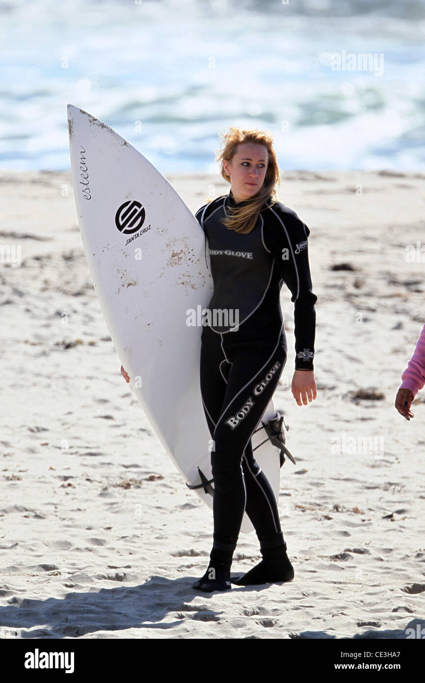 Cast members of the television show '90210' film a beach scene with wetsuits and surfboards in
