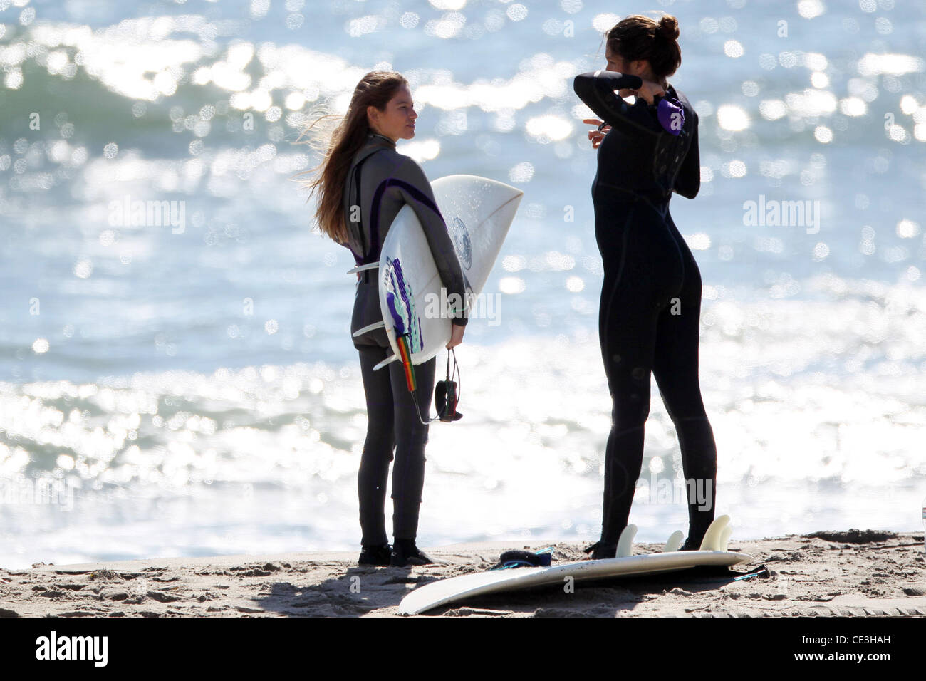Cast members of the television show '90210' film a beach scene with wetsuits and surfboards in