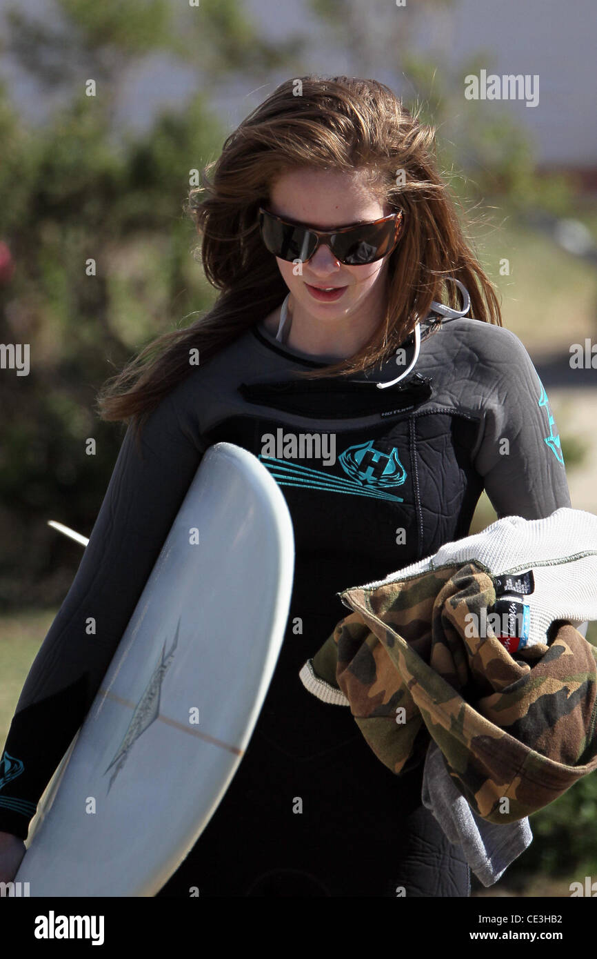 Cast members of the television show '90210' film a beach scene with wetsuits and surfboards in