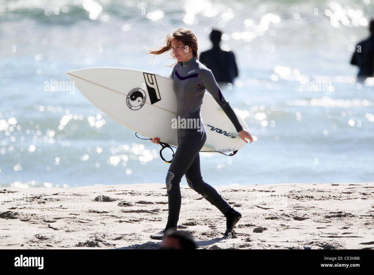 Cast members of the television show '90210' film a beach scene with wetsuits and surfboards in