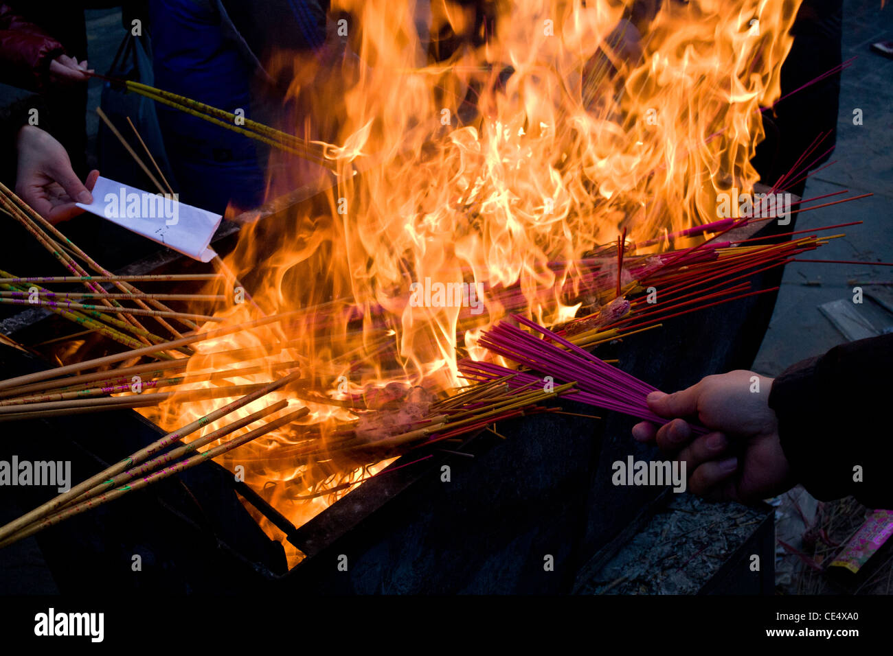 Chinese worshipers are burning incense in the Lamas temple during the New Year of the Dragon (Chunjie), Beijing. Stock Photo