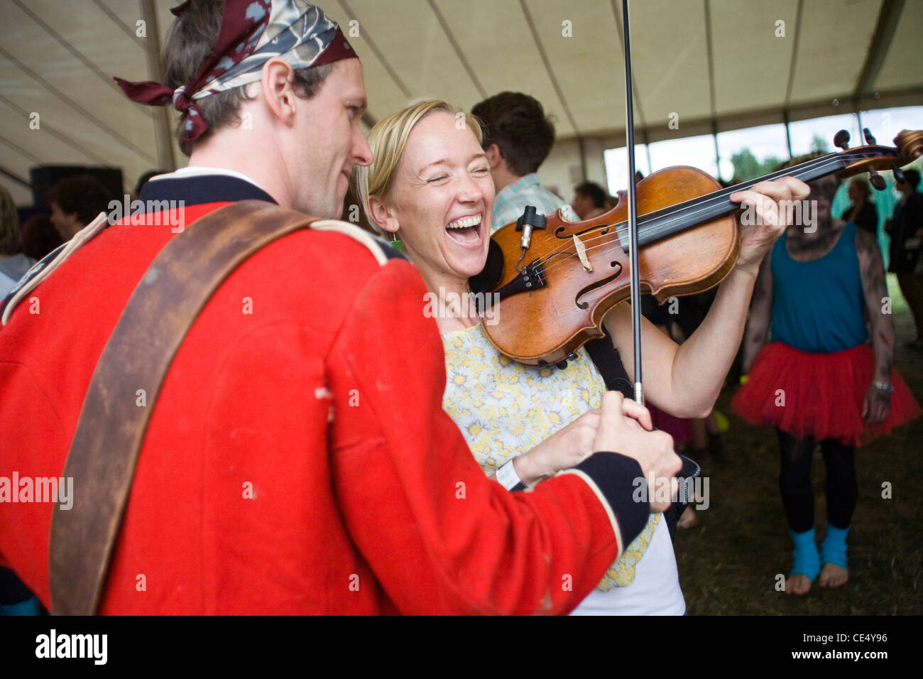 A woman laughs as she plays a violin at the Standon Calling Festival in Hertfordshire, UK Stock Photo