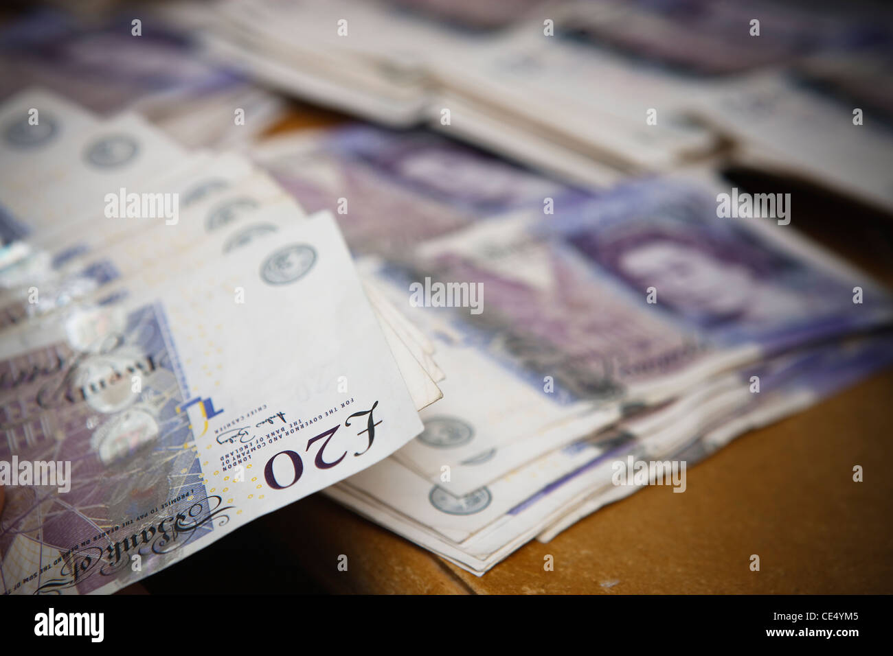 Counting money fan £20 notes GBR sterling currency desk view landscape piles Stock Photo