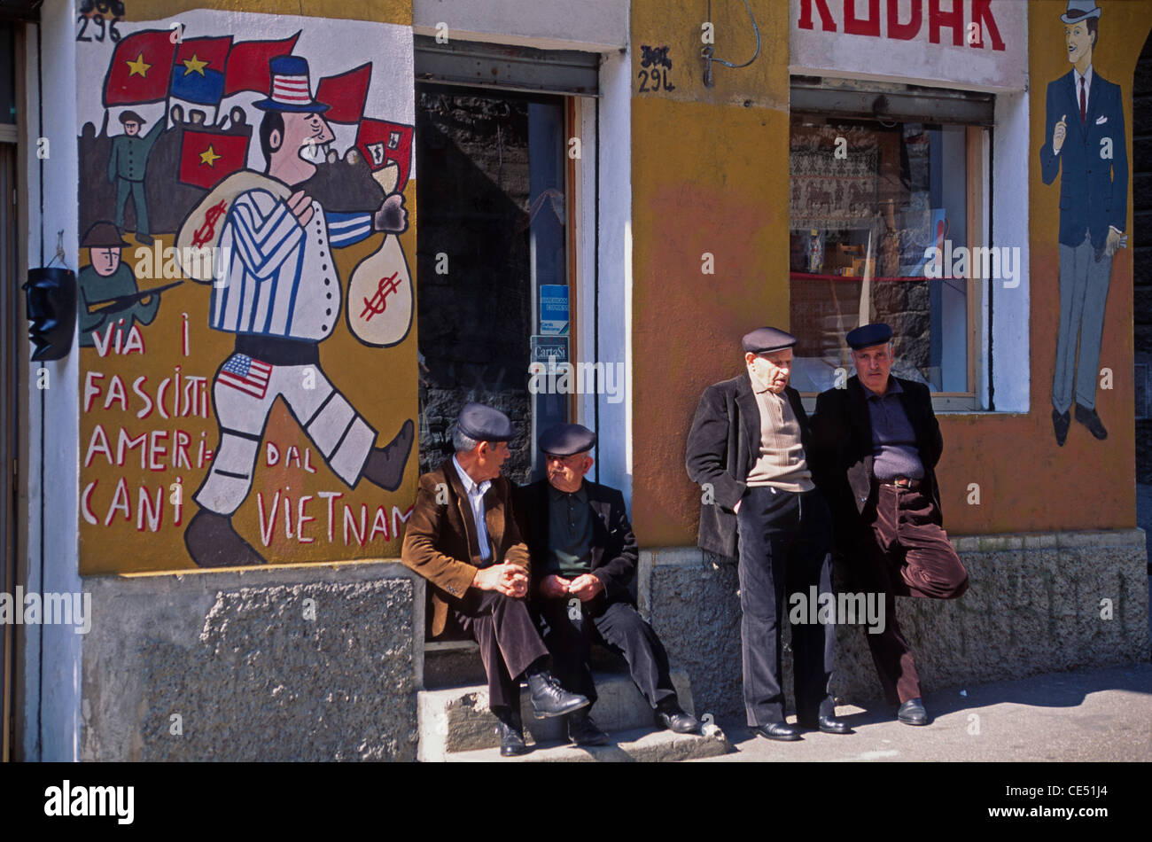 Old Men having a Chat at a store with Murales in Orgosolo Stock Photo