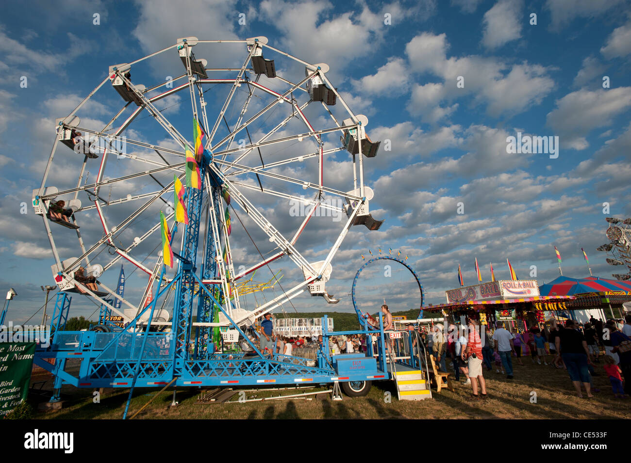 Ferris wheel in front of blue sky and crowd at Mason Dixon Fair Stock Photo