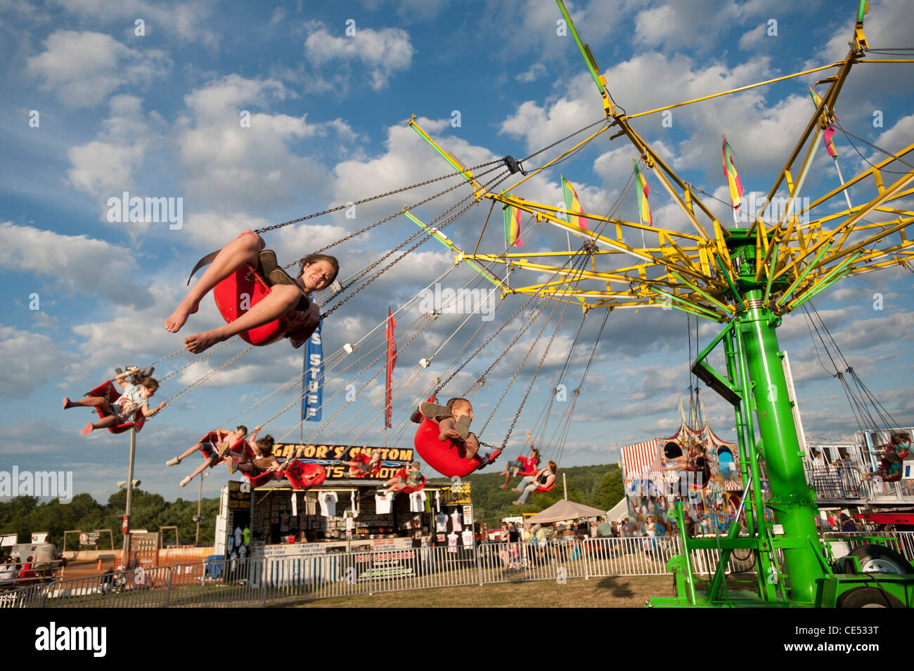 Kids on swinging swings ride in front of blue sky at Mason Dixon Fair