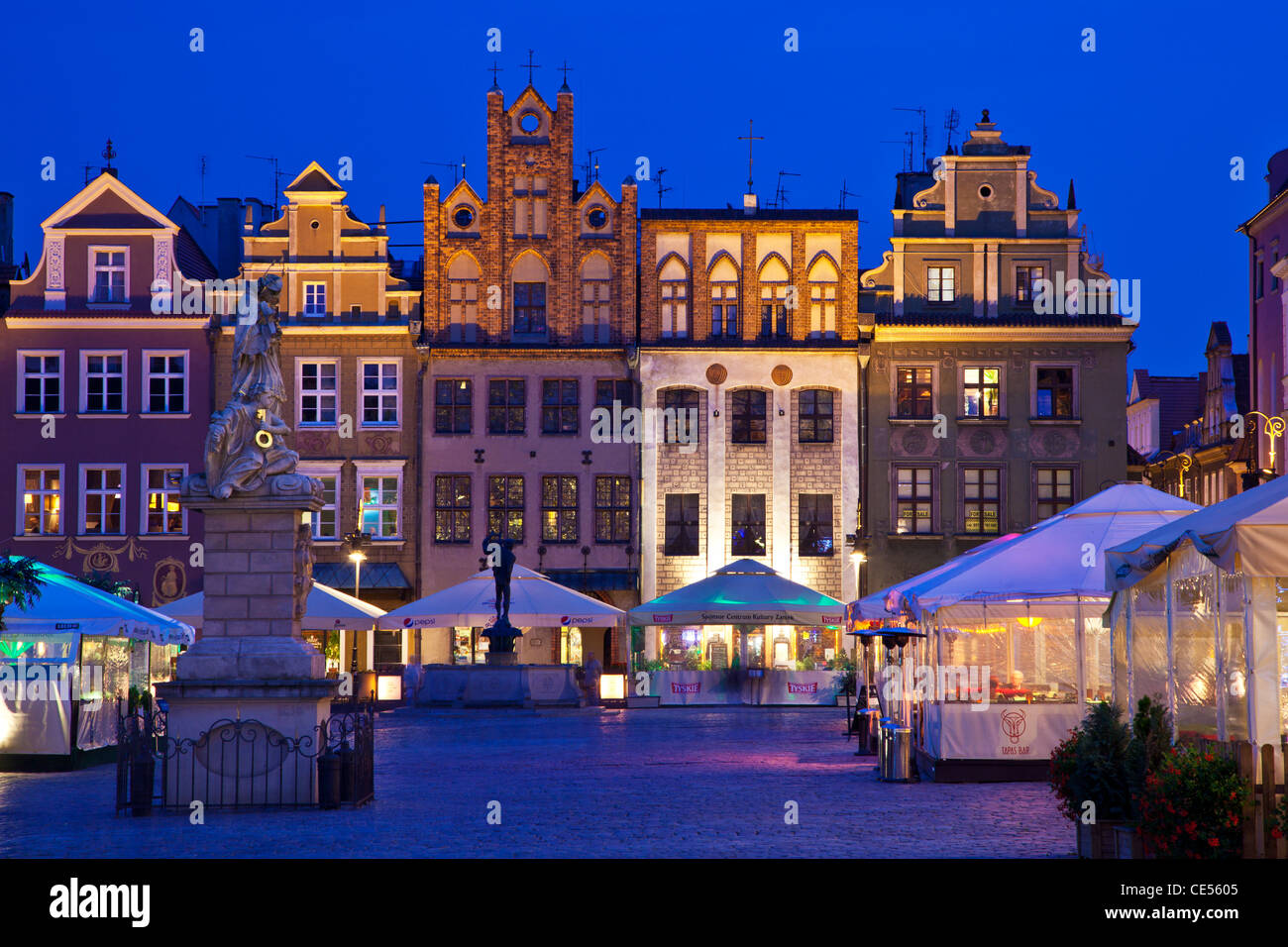 Old town square, Stary Rynek, in Polish city of Poznan, at night. St John Nepomuk statue in foreground, Apollo fountain beyond. Stock Photo