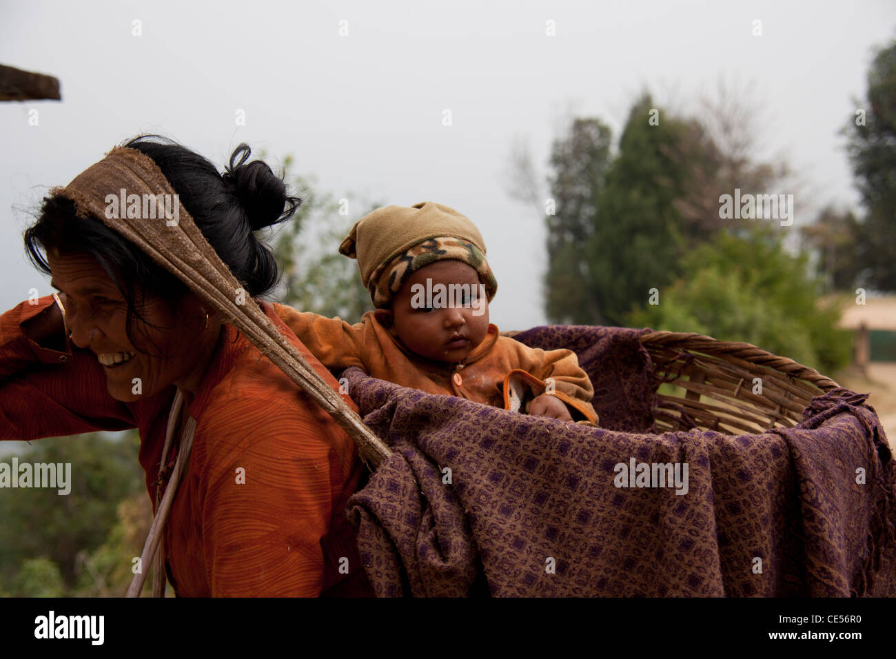 NEPAL KATHMANDU VALLEY DHULIKHAL Newar Woman with baby in  a basket. Stock Photo