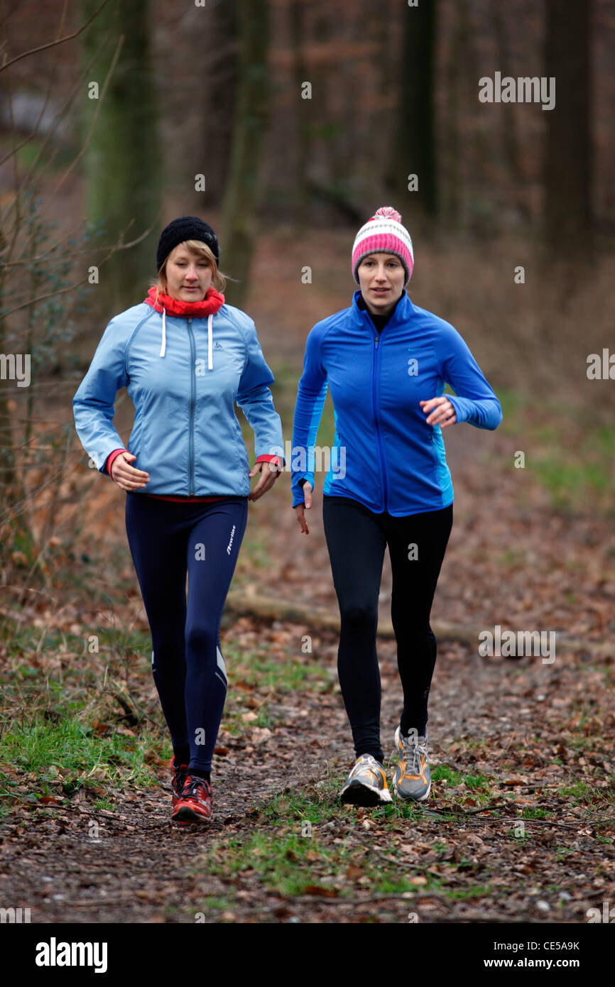 2 young women jogging in winter, in a forest Stock Photo - Alamy