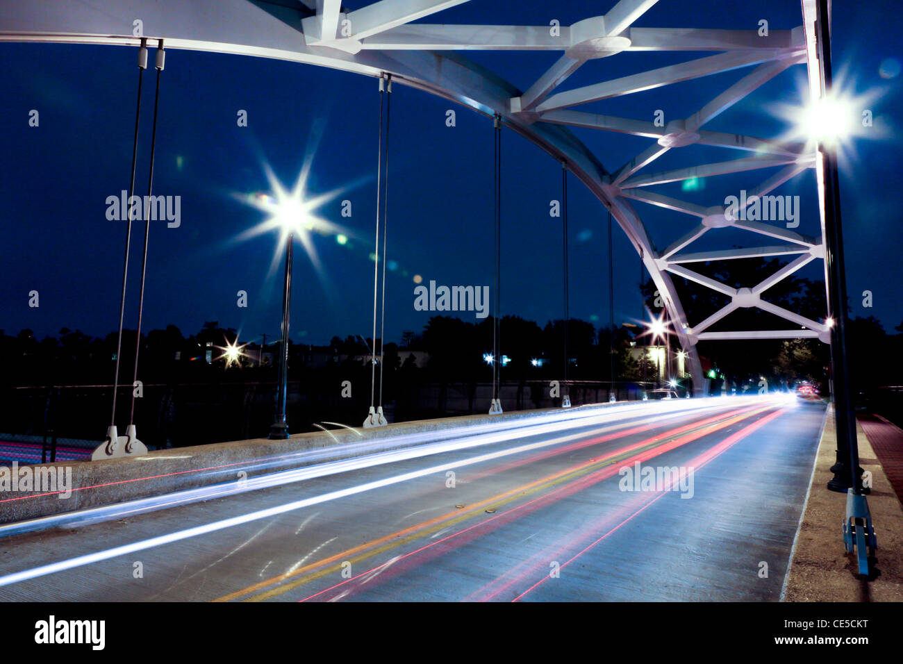 streaking car lights at night crossing over the Graustark Bridge over US-59 in Houston, Texas Stock Photo