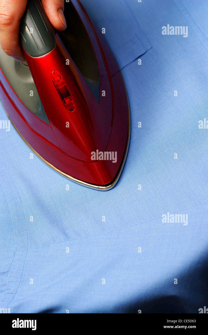 red iron steam ironing a shirt Stock Photo Alamy