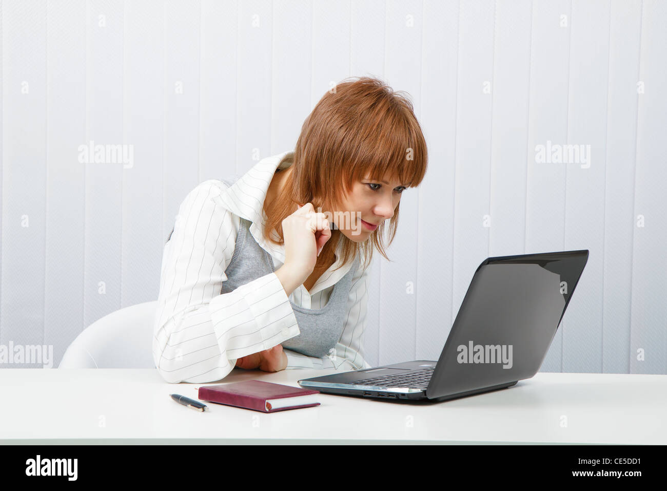 Attractive smiling girl with a laptop in the office Stock Photo - Alamy
