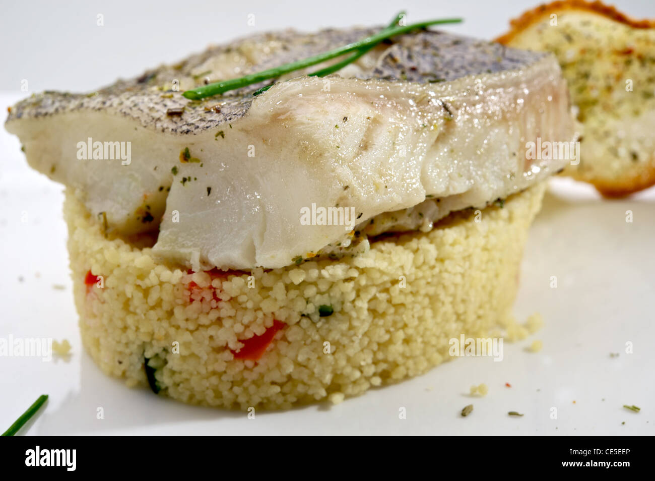 Pike-perch fillet garnished with vegetables and toast, served on white plate Stock Photo