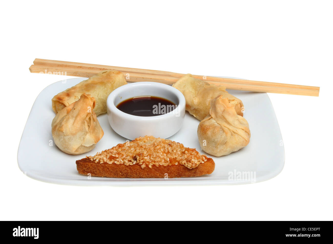 Chinese snacks with soy sauce and chopsticks on a plate isolated against white Stock Photo
