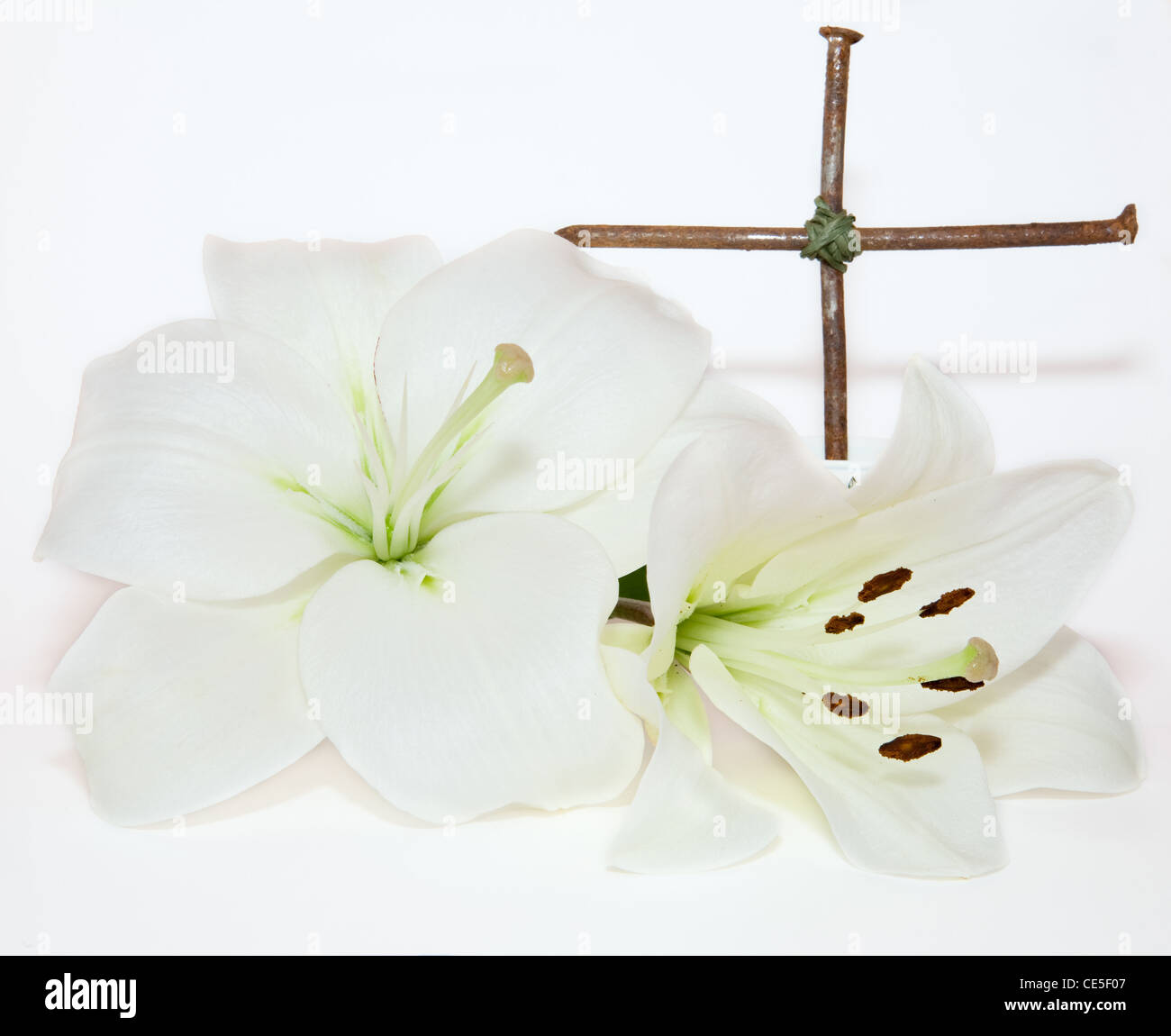 metal crucifix and Easter white Lily on white background Stock Photo