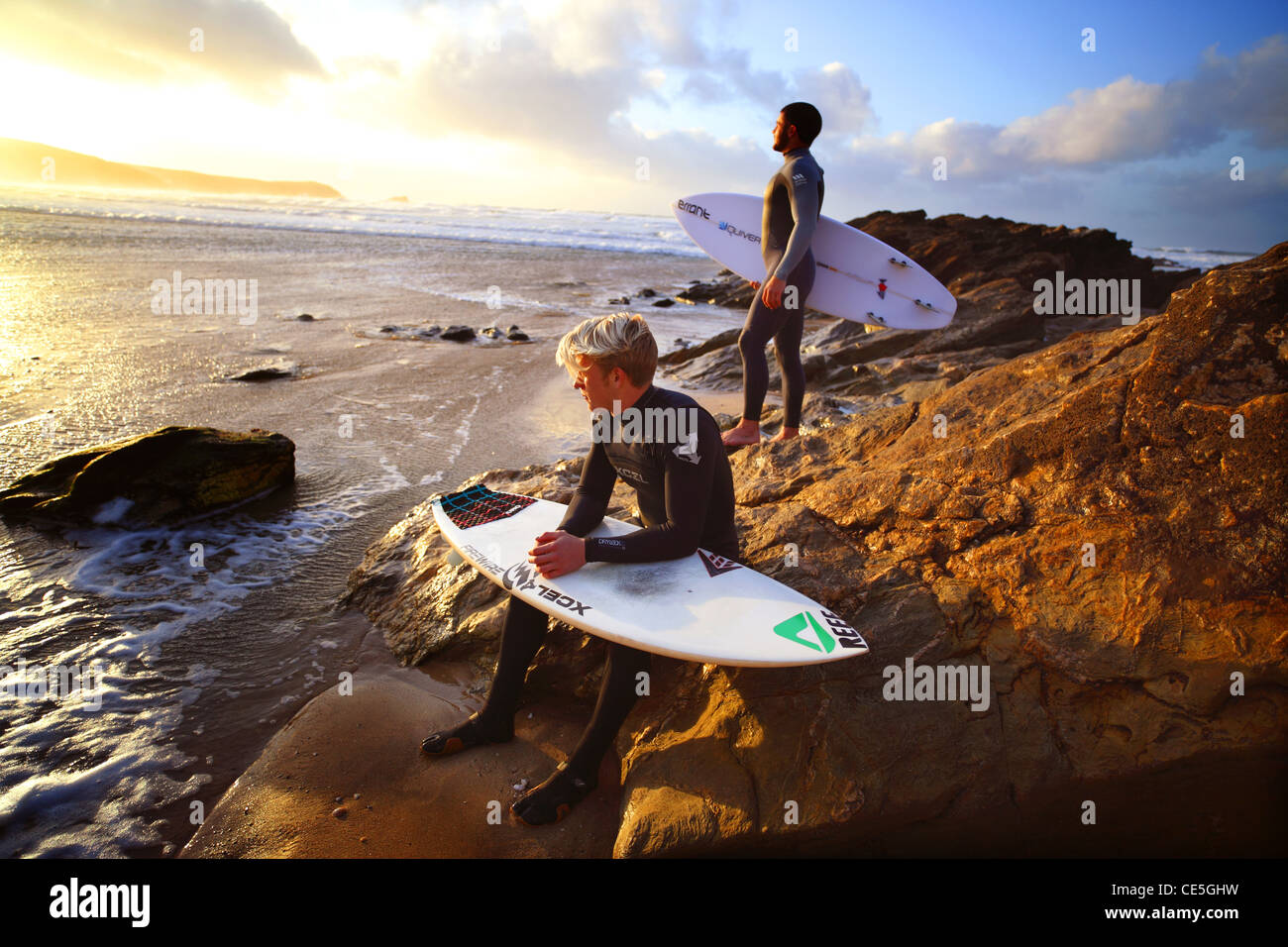 Surfers watch the winter sun go down on Fistral Beach in Newquay, Cornwall, UK. Stock Photo
