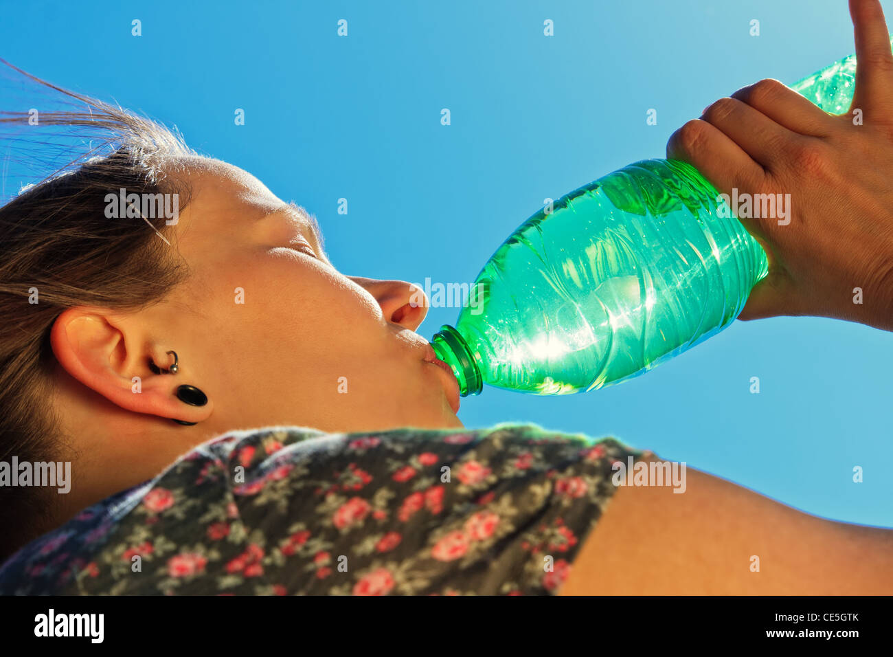 Thirsty woman is drinking fresh water on a sunny day Stock Photo