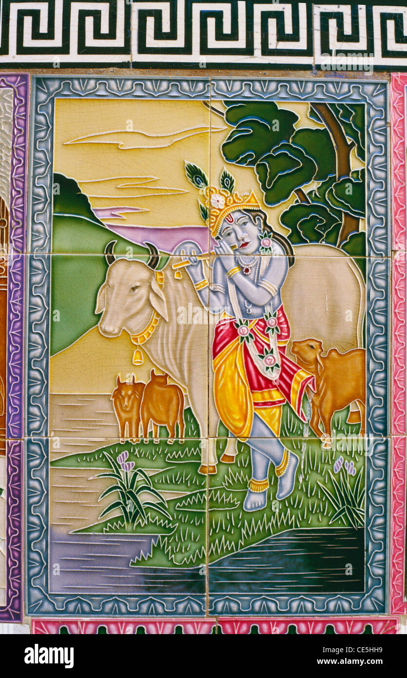 Lord Krishna playing musical instrument flute to cows in garden on glazed ceramic tiles Stock Photo