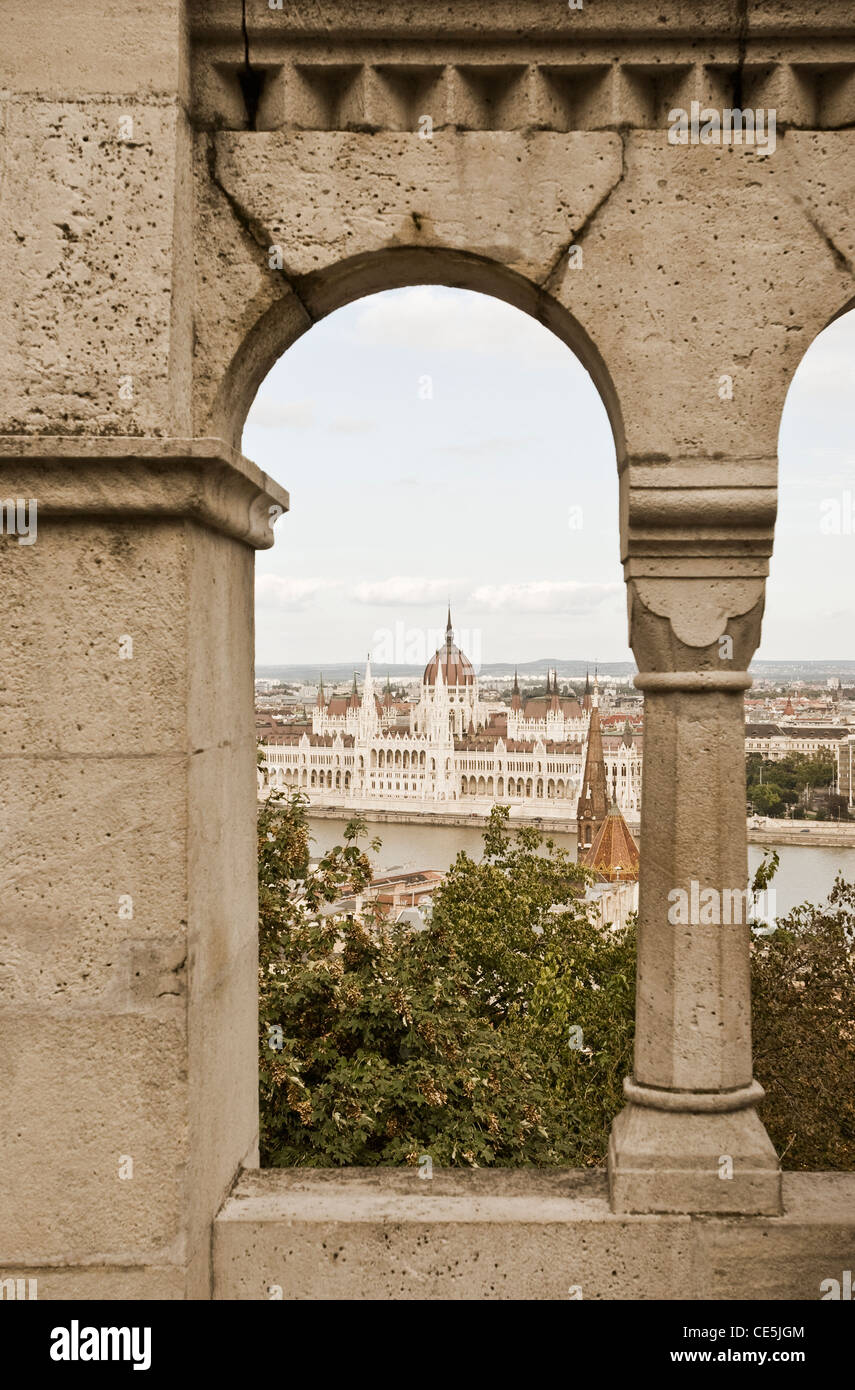 View of the Parliament (Orszaghaz) through the ramparts of Fishermen's Bastion (Halaszbastya), Budapest, Hungary. Stock Photo