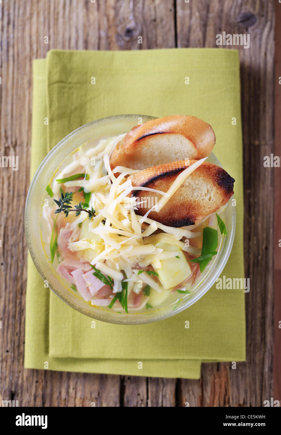 Chicken or garlic soup with grated cheese and ham Stock Photo