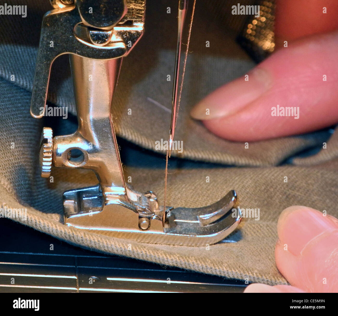 Sewing machine needle and foot (photographer's own hands Stock Photo