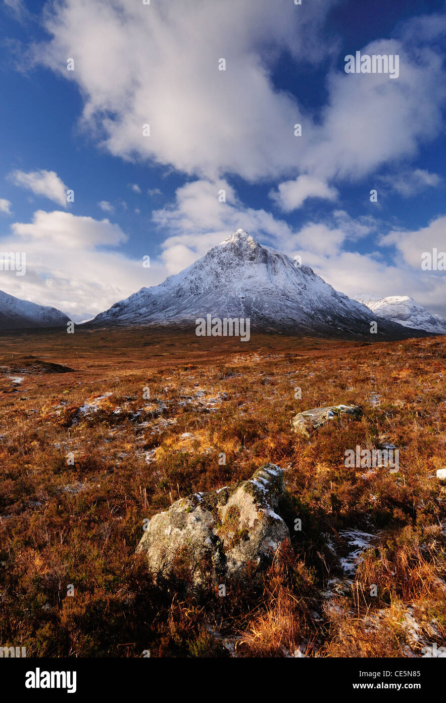 Rocks in Glencoe with the snow capped peak of Stob Dearg on Buachaille Etive Mor in the background, Scottish Highlands, Scotland Stock Photo