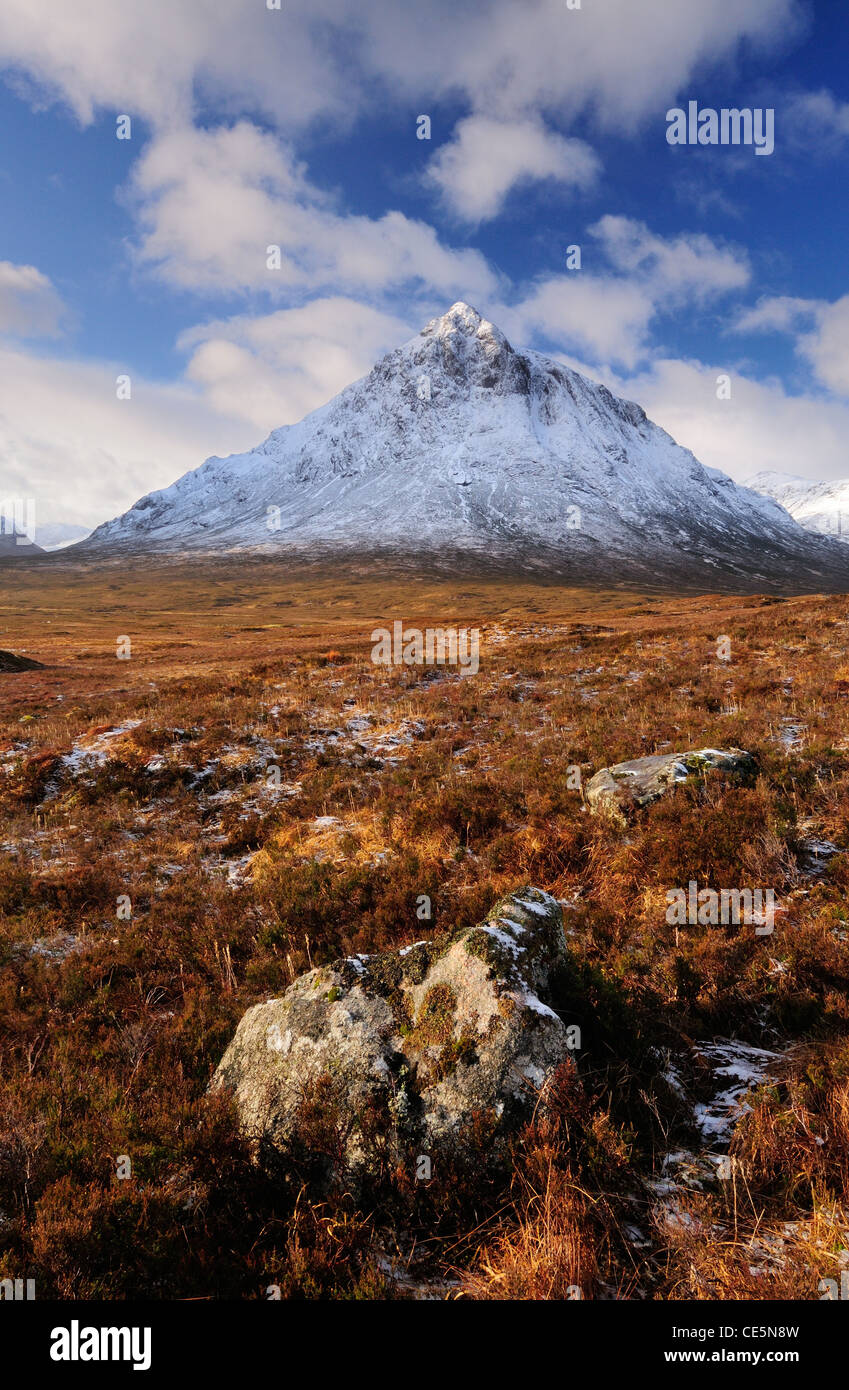 Rocks in Glencoe with the snow capped peak of Stob Dearg on Buachaille Etive Mor in the background, Scottish Highlands, Scotland Stock Photo