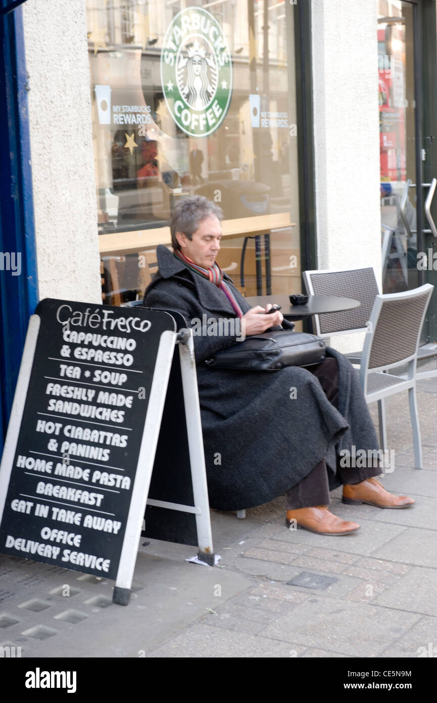 Tottenham Court Road , West End , London middle aged man sitting by