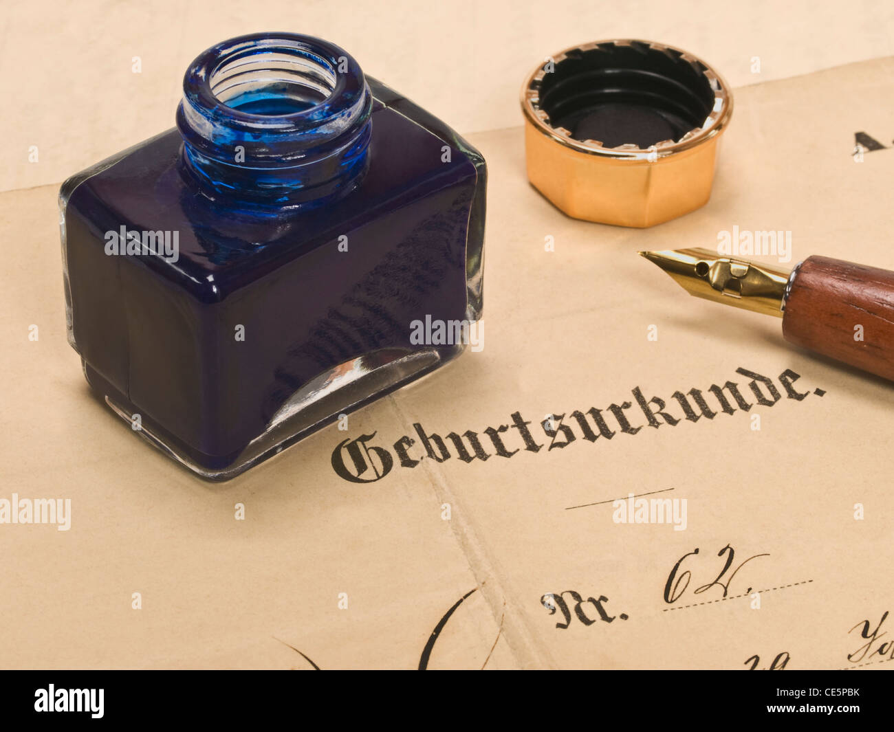 Detail photo of a birth certificate from the year 1913, on it is a ink pot and a pen Stock Photo