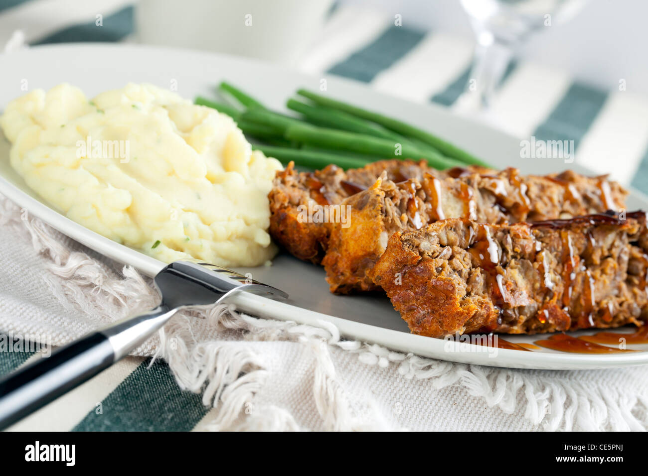 Vegetarian lentil loaf and gravy with mashed potatoes and green beans