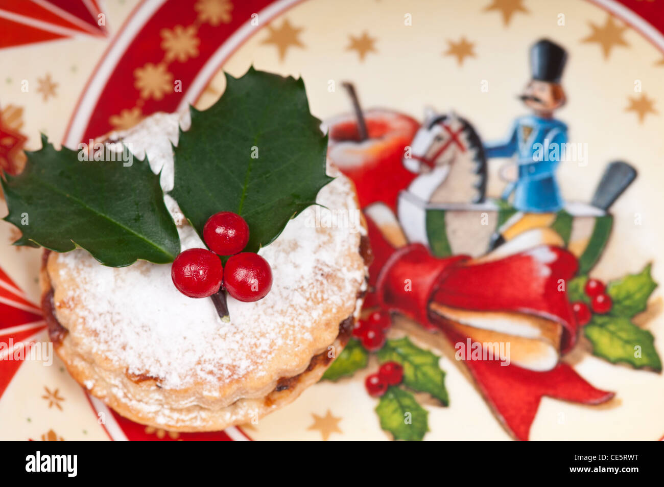 Christmas mincepie decorated with holly and icing sugar on an ...