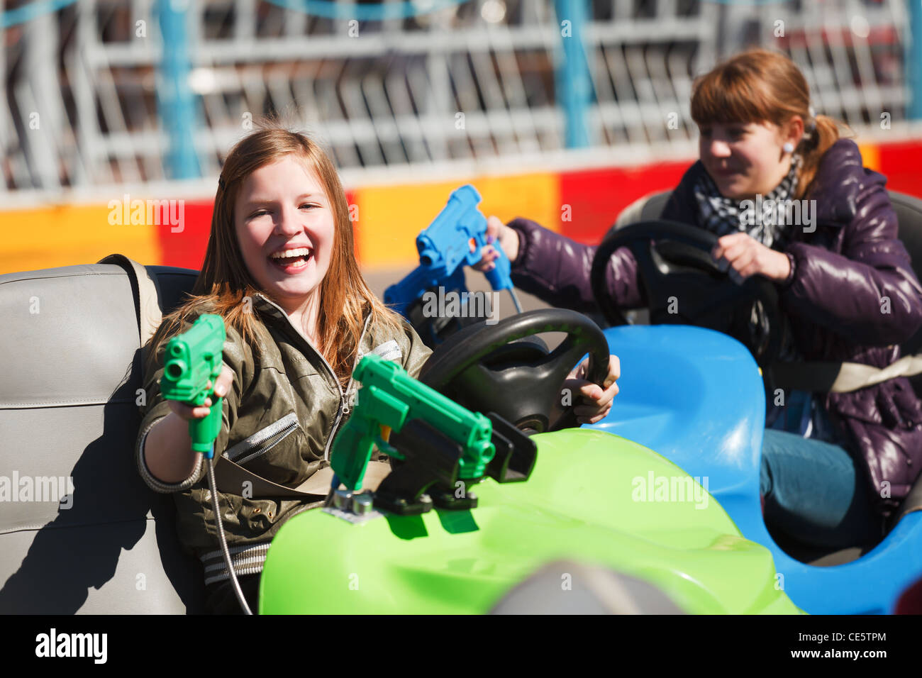 Teenage girls driving a bumper cars Stock Photo Alamy