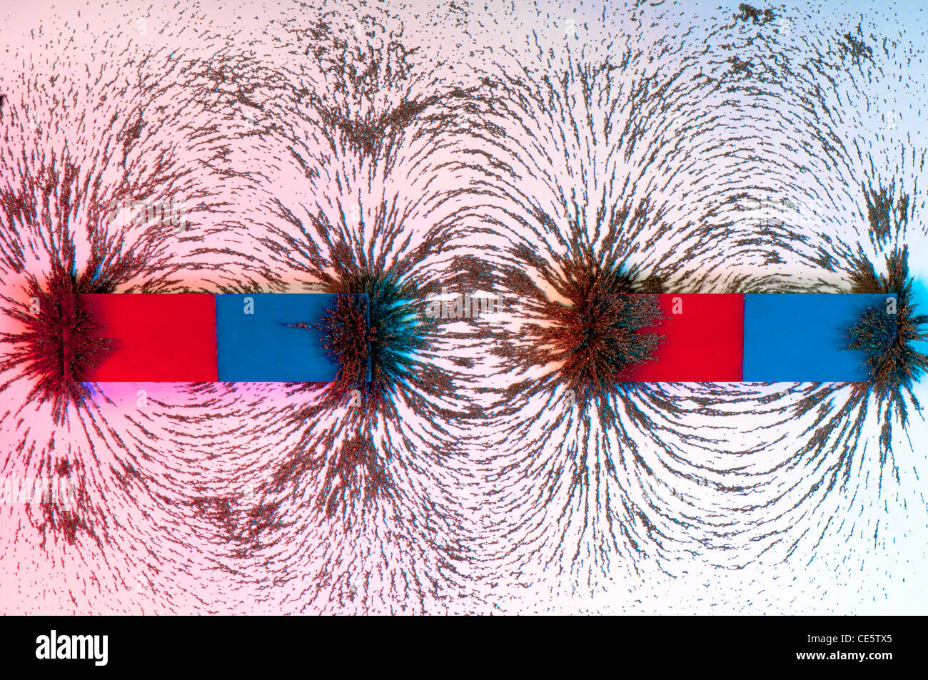 North and south `oles of a magnet with and the curved magnetic field shown by using iron filings in and blue Stock Photo - Alamy