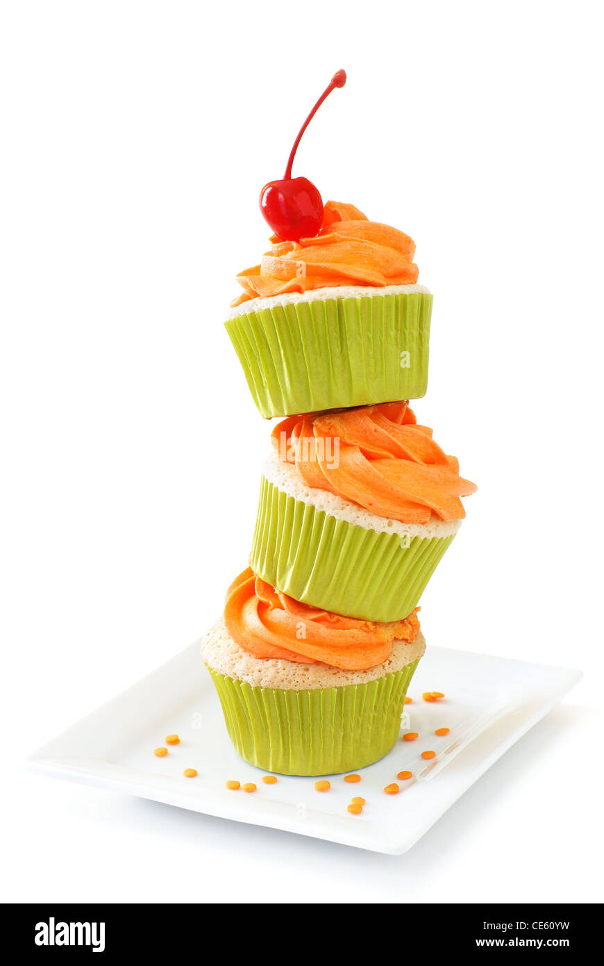 Stacked vanilla cupcakes with orange colored vanilla frosting Stock Photo
