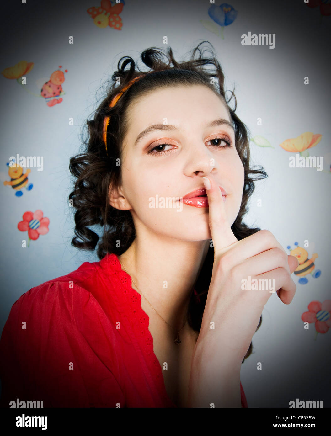 Beautiful curly girl with a finger on lips Stock Photo