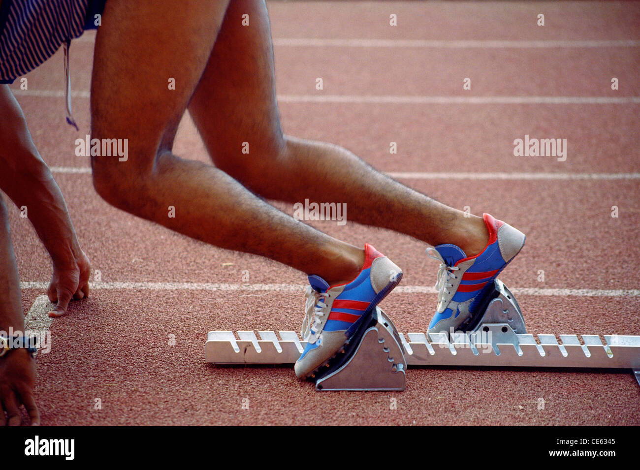 Indian teenager boy athlete runner at starting block on race track