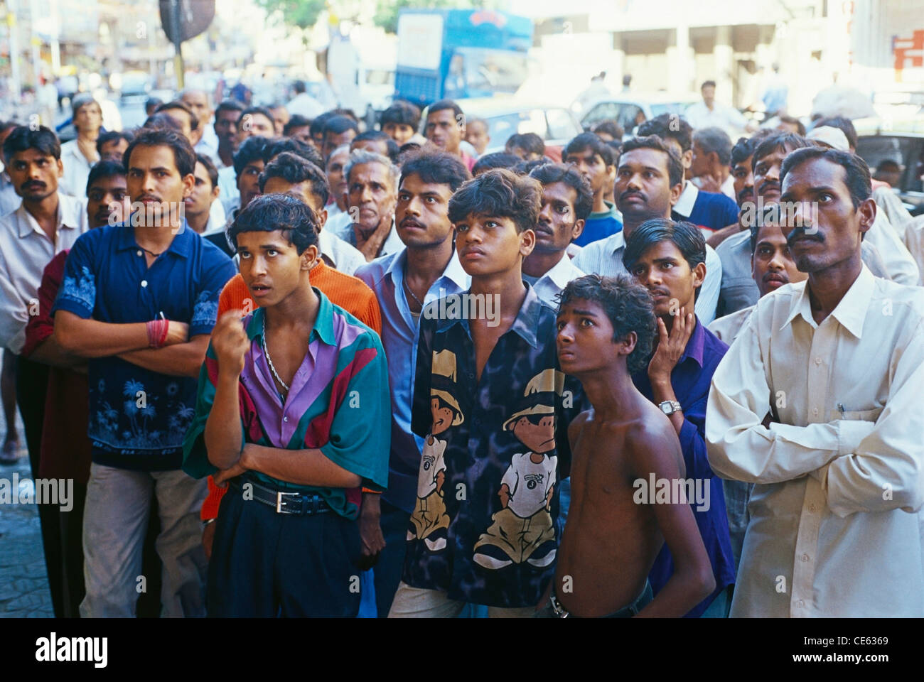 Indian crowd of people watching cricket match on TV in shop window ; Bombay ; Mumbai ; India ; Asia Stock Photo