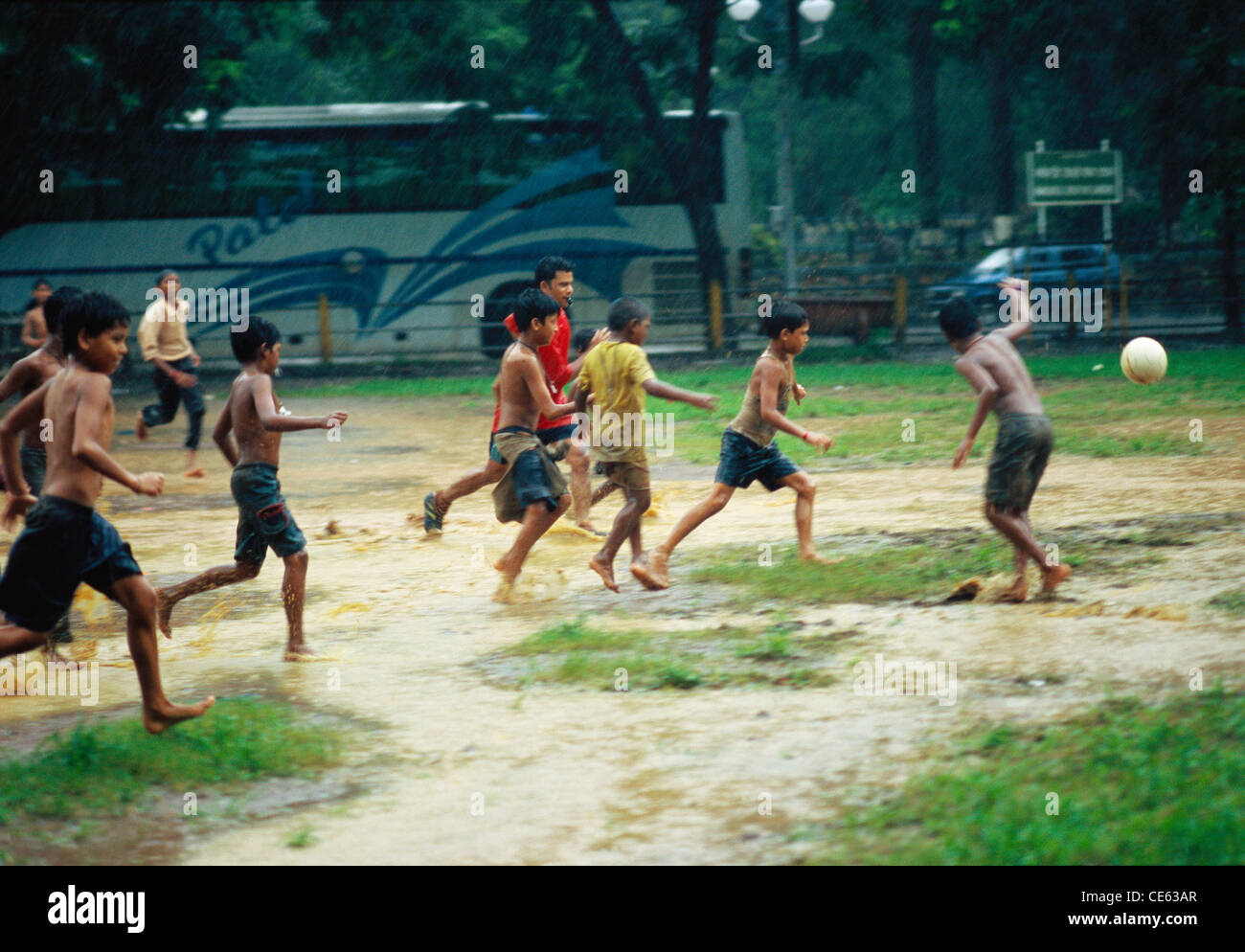 Boys playing football in rain Stock Photo Alamy