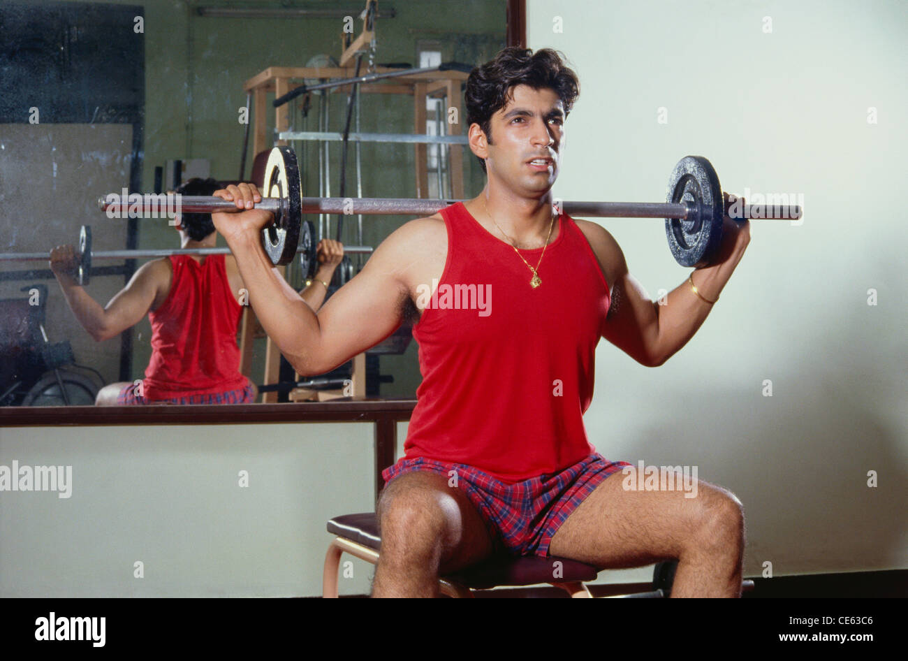 Man doing exercise in gym using weight equipment   MR#139 Stock Photo