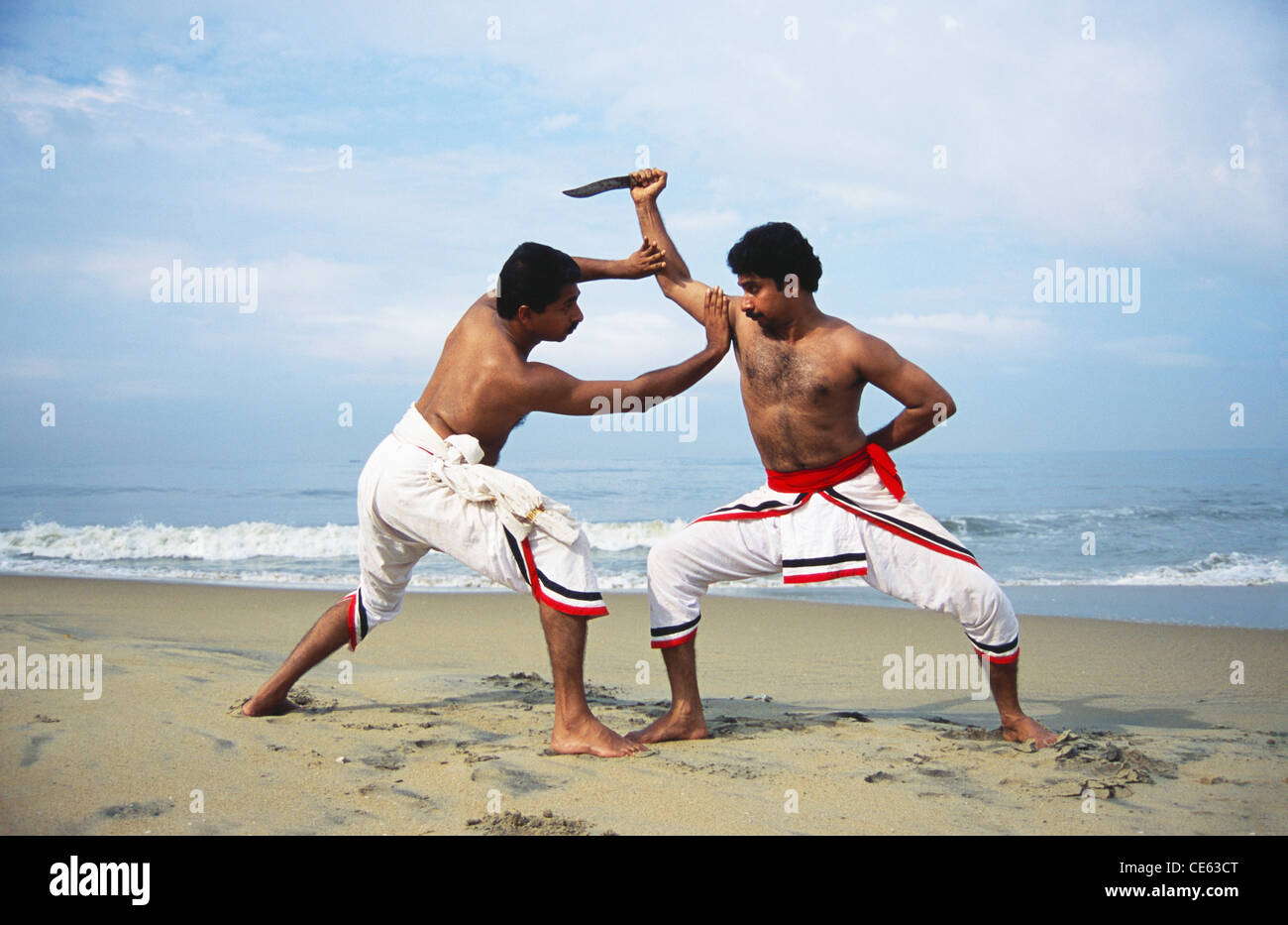 Kalaripayattu ; Kalari ; Indian martial art and fighting style with knife on beach ; Kerala ; India ; Asia ; Indian ; Asian ; MR#1 ; MR#777B Stock Photo
