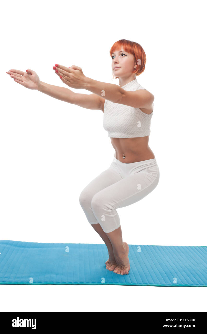 Beautiful red-haired girl practicing yoga or callanetics on white ...